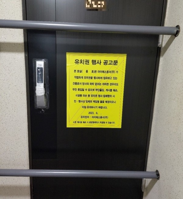 부산 영도구 동삼동 ‘오션라이프 에일린의 뜰 조합원 소유 아파트 현관문에 유치권 행사 문구가 붙어 있다.(사진. 조합원 제공)