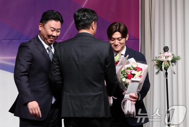 KIA 김도영이 10일 오전 서울 강남구 리베라호텔에서 열린 2024 뉴트리디데이 일구상 시상식에서 최고 타자상을 받은 후 '꽃범호' 이범호 감독과 홍세완 타격코치에게 축하의 꽃다발을 받고 있다. 2024.12.10/뉴스1 ⓒ News1 김성진 기자