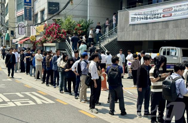 제21대 대통령선거 사전투표 첫 날인 29일 서울 종로구 종로1·2·3·4가동 주민센터 투표소에 마련된 투표소에서 직장인들이 점심시간을 이용해 투표를 위해 길게 줄을 늘어서 있다. 사전투표 첫날 오후 1시 기준 전국 평균 투표율은 지난 20대 대선(36.93%)의 같은 시각 투표율(8.75%)보다 1.76% 높은 10.51%로 역대 최고치다. 2025.5.29/뉴스1 ⓒ News1 유승관 기자