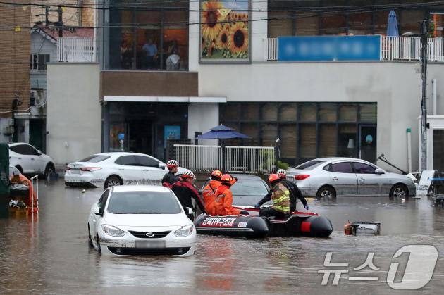 지난 17일 오후 대구 북구 노곡동 마을이 집중호우에 침수돼 119구조대가 고립된 주민을 구조하기 위해 구명보트를 타고 마을로 들어가고 있다. 뉴스1 ⓒ News1 공정식 기자