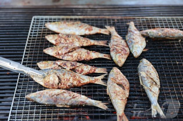 22일 열린 전남 보성전어축제에서 참가자들이 잡은 전어를 현장에서 직접 구워주고 있다.(보성군 제공. 재배포 및 DB 금지) 2025.8.24/뉴스1