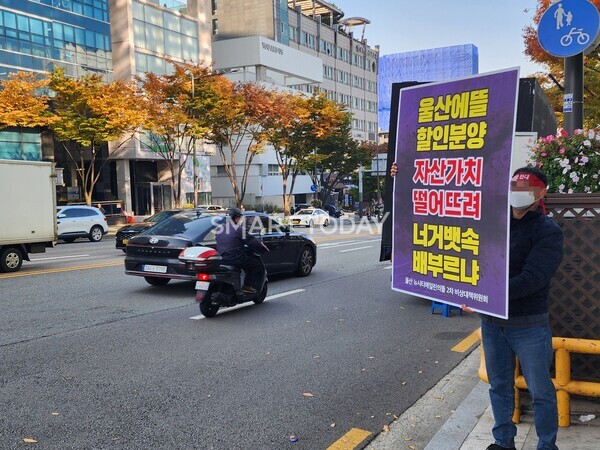 울산뉴시티 비대위 관계자가 도로가에서 아이에스동서 할인분양을 규탄하는 피켓을 들고 서 있다. 출처=김종현 기자