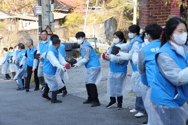  * 쌍용C&E 본사 임직원들이 서울시 성북구 정릉3동 1통 일대에서 연탄을 전달하고 있는 모습. 사진 제공=쌍용C&E