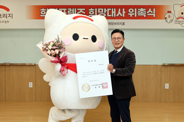 희망브리지 신훈 사무총장이 공식 캐릭터 '희망프렌즈'를 희망대사로 위촉하고 기념사진 촬영을 하고 있다.(사진제공=희망브리지)