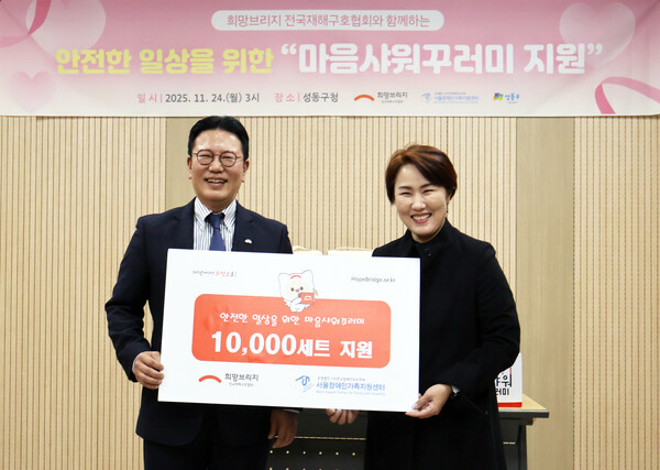 신훈 희망브리지 사무총장(왼쪽)과 김남연 서울장애인가족지원세터 광역센터장이 재난 취약계층을 위한 마음샤워꾸러미 1만세트 전달식에서 기념촬영을 하고 있다.(사진제공=희망브리지)